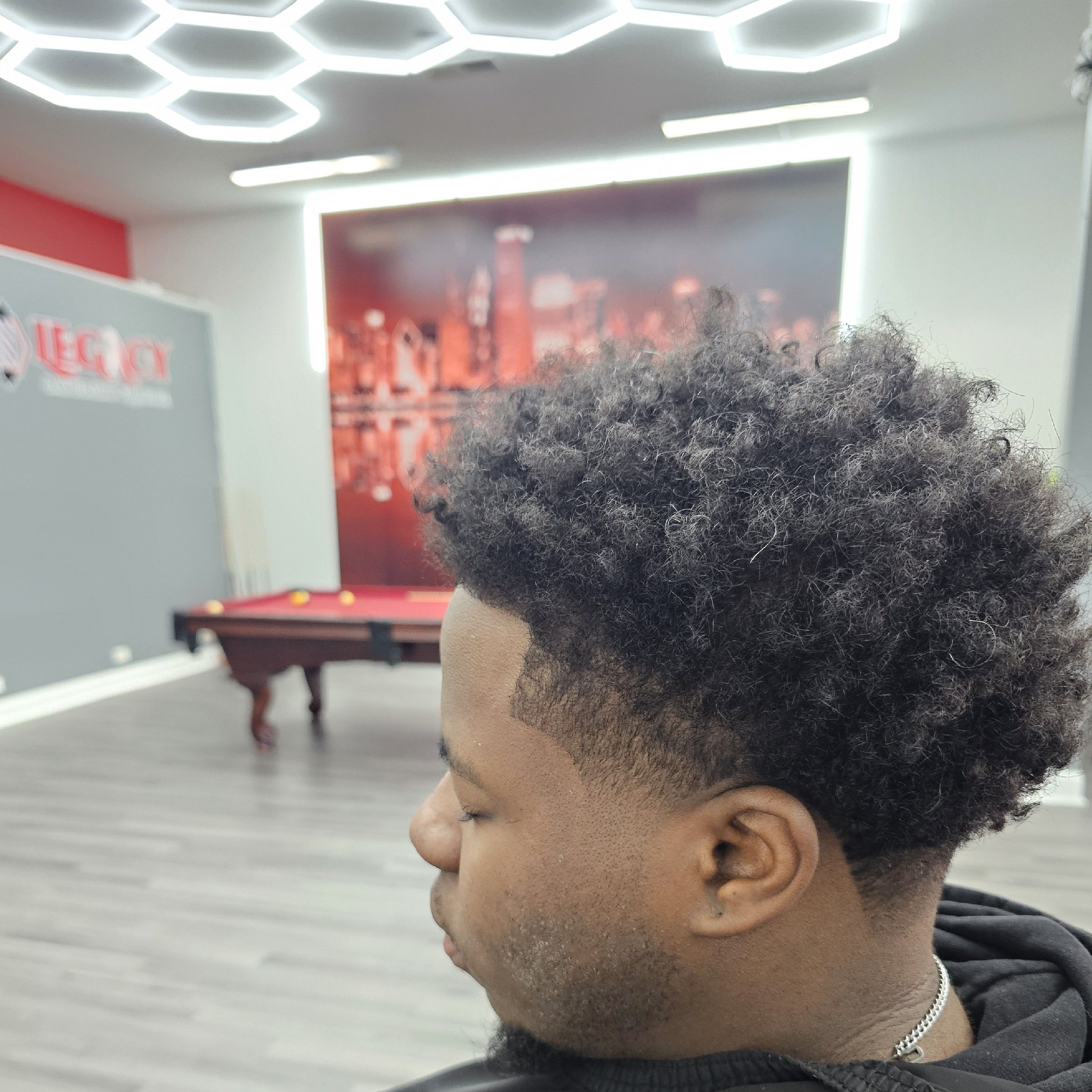 Curly top with the lounge and pool table in the background, Legacy Barbershop & Lounge