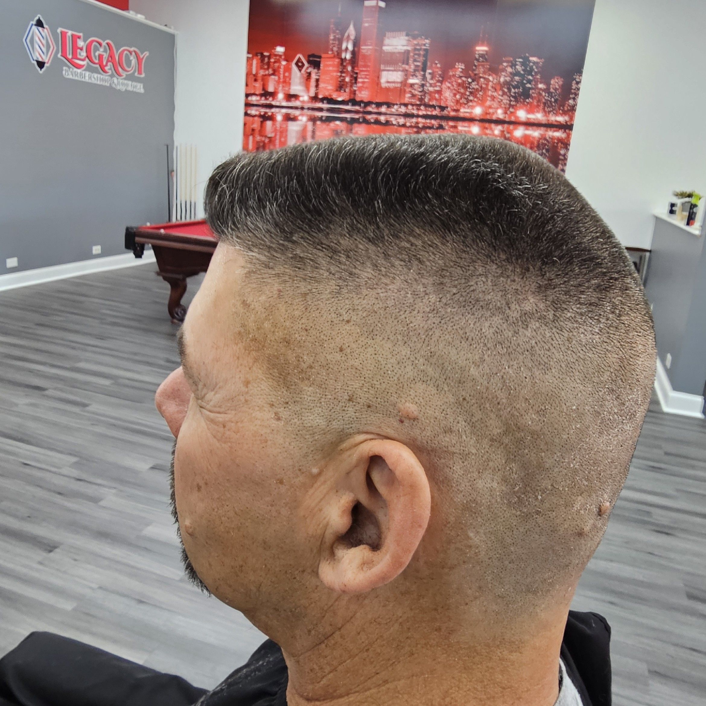 High-and-tight cut with the Chicago skyline mural behind, Legacy Barbershop & Lounge